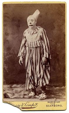 an old photo of a clown in striped clothes