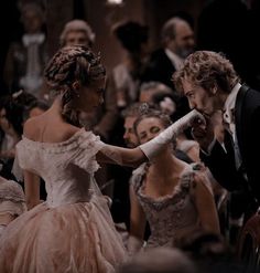 a man in a tuxedo standing next to a woman in a ball gown