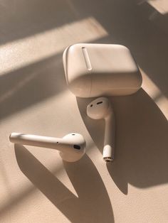 an apple airpods sitting on top of a table next to another earbud