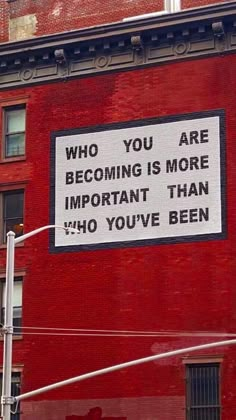 a sign on the side of a building that says, who you are becoming is more important than ho you've been