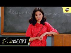 a woman standing in front of a blackboard with writing on it