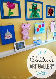 the wall is decorated with art and pictures on it, along with a blue frame that says diy children's art gallery