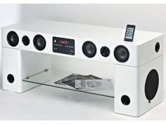 a white table with speakers on it and an ipod sitting on top of the shelf