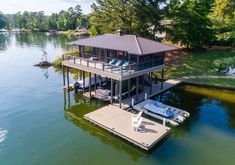 an aerial view of a house on the water with a boat dock and lounge chairs