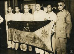 an old black and white photo shows men standing around a large piece of cloth that has been draped over it