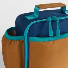 A fun and functional lunch box that's built to handle all the thrills and spills of the day. Combining colorblocks of navy and ocher with pops of aqua trim, our bag is constructed of food-safe and supremely durable polyester made from recycled water bottles. It's also lightweight and easy to clean, plus roomy enough to hold multiple storage containers. An insulated lining keeps meals just the way your kid likes them—hot, cold or somewhere in between. An outer pocket safely stows a napkin, utensi Back To School Rectangular Lunch Box For Outdoor Activities, Durable Rectangular Lunch Bag For School, Functional Rectangular Lunch Box For Back To School, Functional Rectangular Lunch Box For Outdoor, Functional Rectangular Lunch Box For School, Functional Multicolor Lunch Box For Everyday Use, Functional Lunch Box For Back To School, Functional Blue Lunch Box For Outdoor Activities, Functional Blue Lunch Bag For Everyday Use