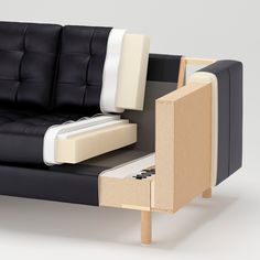 a black and white couch with an open drawer on the armrests next to it