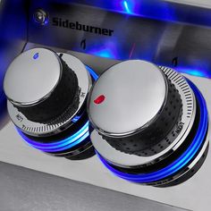 two knobs on the side of a stove with blue light coming from behind them