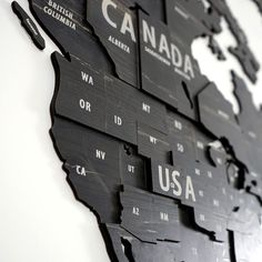 the map of the united states is made out of black wood and has white letters