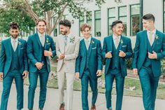 a group of men in suits and ties standing next to each other on the sidewalk