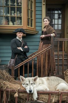 two people and a dog are standing on the steps