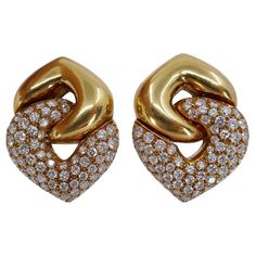 A pair of the classic Bulgari Doppio Cuore earrings in yellow gold, featuring diamonds. The earrings are designed as two interlocked hearts: a gold reversed heart holds a diamond one. This pair is the largest in the wide range of the collection's sizes. The heart design is one of the widely using element in Bulgari jewelry making. It reflects the brand's ability to infuse romance and passion into a piece. Bulgari's heart design is not only visually captivating but also emotionally resonant. Whet Luxury Heart-shaped Diamond Earrings, Luxury Gold Heart Earrings For Formal Occasions, Gold Luxury Heart Earrings For Formal Occasions, Formal Yellow Gold Double Heart Earrings, Formal Heart-shaped Yellow Gold Diamond Earrings, Luxury Heart Earrings With Diamond Accents, Luxury Heart Earrings With Diamond Accents For Formal Occasions, Formal Diamond Double Heart Earrings, Gold Heart Earrings With Brilliant Cut For Formal Occasions