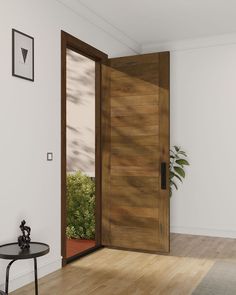 an open door in a white room with wood flooring and potted plant next to it