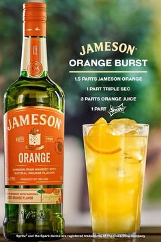 a bottle of jameson orange burst next to a glass with an orange slice in it