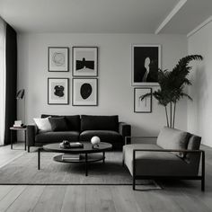 a black and white living room with pictures hanging on the wall, couches and coffee table