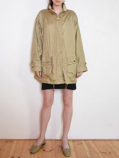 Cool vintage lightweight jacket / windbreaker- made  of textured, golden beige taffeta fabric. Loose parka fit, with drawstrings to regulate the waist and the bottom hem. Hidden zip with brass-colored rectangular snaps. Nice detail - rolled up sleeve cuffs with rounded patches decorated with snaps. Two large front pockets, one zipped "secret" front pocket, and some buttoned one inside. Gently padded arms give it a sporty elegance feel. Era: 90's, brand Windfield - Great Outdoor Wear Fabric: oute Khaki Nylon Parka For Fall, Beige Nylon Windbreaker For Winter, Oversized Beige Windbreaker With Long Sleeves, Oversized Beige Long Sleeve Windbreaker, Beige Windbreaker With Pockets For Spring, Khaki Long Sleeve Nylon Parka, Oversized Beige Windbreaker For Fall, Spring Nylon Utility Jacket With Long Sleeves, Spring Nylon Long Sleeve Utility Jacket