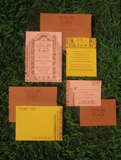 the wedding stationery is laid out on the grass