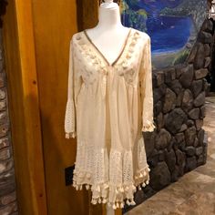 Brand New With Tags Absolutely Stunning Made Of The Highest Quality Tassel And Metallic Accents A-Line Flattering Style We Are A Licensed Retailer For Ranee’s Boutique Clothing V-neck Vacation Dress With Tassel Ties, Cream Long Sleeve Beach Cover-up Dress, Spring Beach Cover-up Dress With Tassels, Bohemian V-neck Dress With Crochet Trim, Boho Mini Dress With Lace Trim For Vacation, Vacation Boho Dress With Lace Trim And Mini Length, Chic V-neck Mini Dress With Tassels, V-neck Mini Dress With Crochet Trim For Vacation, Chic Beaded Fringe Mini Dress For Spring