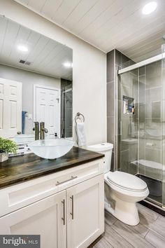 a bathroom with a sink, toilet and shower stall in the middle of the room