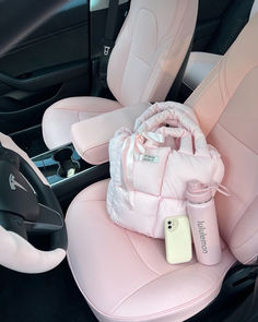 the interior of a car with pink leather seats and baby items in front of it