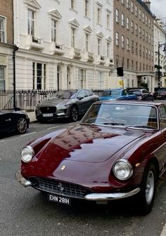 an old red car is parked on the street