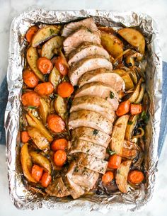 chicken, potatoes and carrots on foil in a baking pan