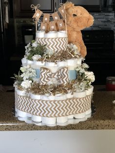 a diaper cake that has a teddy bear on top and baby's first birthday decorations