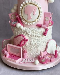 a pink and white cake with lots of decorations on it's top tiers