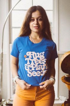 Show your love for the planet with the Hug Trees Vintage Graphic Tee. Perfect for creating a laid-back 70s inspired fashion look, this retro shirt design blends vintage style with eco-conscious messaging. Pair this graphic shirt with retro outfits for women to create the perfect tshirt outfit. Tender Loving Care, Plant Seeds