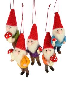 four gnome ornaments hanging from strings on a white background