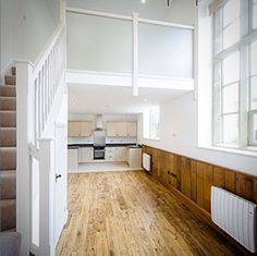 an empty room with wooden floors and white walls