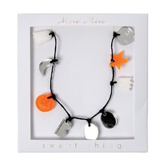 an orange and white necklace in a box with the words sweet thing written on it