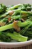 a white bowl filled with broccoli and other vegetables on top of a table