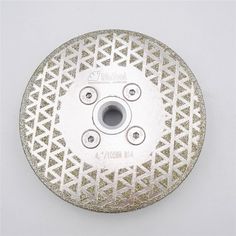 a diamond grinding wheel on a white surface with an intricate pattern and holes in the center