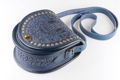 "Blue bag with metal, round leather bag, embossed bag, blue leather purse, crossbody bag, tooled blue bag, gift for her, shoulder purse Model \"Guelder rose\"+metal Unique handmade bag made of premium 4 mm genuine calf leather. Made using rare technology of hot tooling. Ornamented with grape vines and cluster of grapes images, decorated with metal. Super comfortable, durable and functional. Has one big compartment, one internal zip-pocket and one button pocket, e.g. for cell phone or keys. Dimen Hand-tooled Blue Crossbody Shoulder Bag, Hand Tooled Blue Crossbody Bag, Blue Hand Tooled Leather Shoulder Bag, Blue Leather Hand Tooled Shoulder Bag, Hand Tooled Blue Leather Shoulder Bag, Grapes Images, Guelder Rose, Grey Crossbody Bag, Red Leather Purse