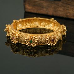 If simplicity with an elegant look had a voice, this Indian Bangle Set would describe itself as such. Our Wedding bangles are understated in appearance but opulent in detail, and it exudes an air of carefree, innocent playfulness giving you a feel of Indian jewelry articulation. You must not miss this timeless piece! You should wear this bangle set once and never take it off. It looks well with both professional and informal attire, giving them a little more sparkle and sheen. Add charm to your beautiful personality with this beautiful gold plated stone bangle lined with synthetic ruby and synthetic emerald. Note: The Gold bangle comes single. NOTE: This product has been crafted by hand and may have slight irregularities or imperfections in color or embellishment. These irregularities resu Intricate Design Bracelet Jewelry For Marriage, Intricate Design Bangle For Marriage, Tilla Bangle Jewelry For Marriage, Fusion Style Openable Bangle For Wedding, Elegant Tilla Cuff Bracelet For Wedding, Intricate Design Bangle Bracelet For Marriage, Wedding Gold Bangle Bracelet With Intricate Design, Marriage Bangle Bracelet With Intricate Design, Wedding Bangle Bracelet With Intricate Design