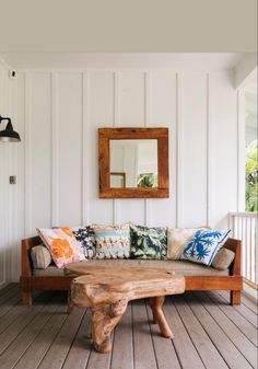 a couch sitting on top of a wooden floor next to a mirror