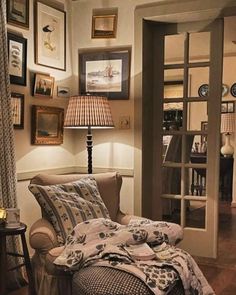 a living room filled with furniture and framed pictures on the wall above an open door