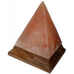 a large pink stone pyramid sitting on top of a wooden base