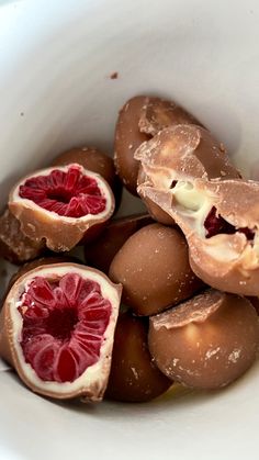 a white bowl filled with blood oranges on top of a table