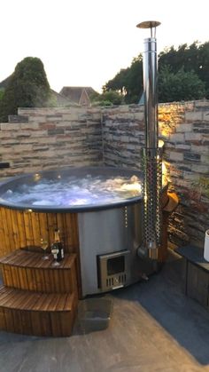 a hot tub sitting next to a stone wall