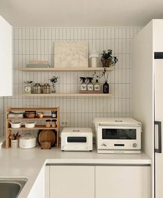 a kitchen with white cabinets and shelves filled with pots, pans, and other items