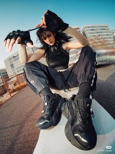 a woman sitting on top of a skateboard next to a pair of black shoes