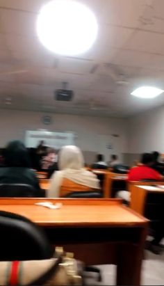 blurry photograph of people sitting at desks in an office