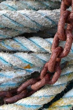 a close up of a rope with some links attached to it and other ropes in the background