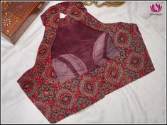 A red kalamkari readymade blouse is a stunning piece that combines the rich and intricate Kalamkari art with the vibrant hue of red. This comes with high-collared and designed with a structured neckline that extends upward, offering a polished and elegant look. It has a soft pad. It is sleeveless and has a back opening. Pairing tip: Pair it up with any kind of cotton sarees in contrasting colors. Size: 38. Please note: Color may vary slightly from the picture. Red Anarkali Blouse With Traditional Patterns, Red Blouse With Traditional Patterns For Navratri, Red Block Print Blouse Piece For Diwali, Fitted Red Kalamkari Print Saree, Red Choli With Kalamkari Print For Navratri, Red Kalamkari Choli For Navratri, Fitted Red Kalamkari Print Blouse Piece, Red Saree Blouse With Block Print, Traditional Red Blouse With Kalamkari Print