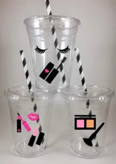 four plastic cups with black and white striped straws in the shape of eye lashes