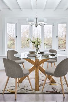 a dining room table with four chairs and a chandelier hanging from the ceiling