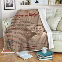 a blanket with an image of a woman on it next to books and a cup