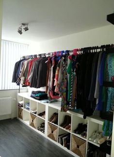 the closet is full of clothes and shoes for all to see in this room,